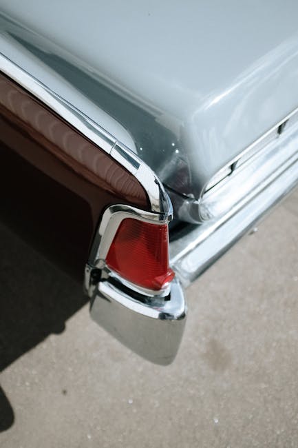 Detailed view of a vintage car's tail light, showcasing chrome and classic design elements.