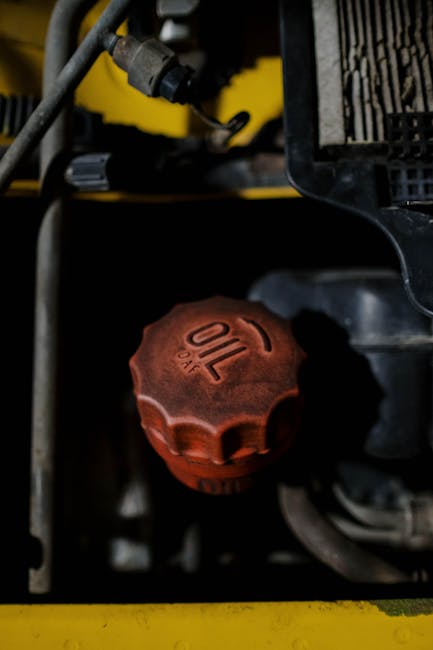 Detailed view of a red oil cap on machinery, emphasizing industrial design.